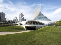 a building designed like a flying whale with modern architecture in the background, on the park area