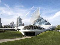 a building designed like a flying whale with modern architecture in the background, on the park area