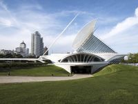 a building designed like a flying whale with modern architecture in the background, on the park area