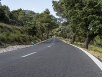 a long, straight road is empty from motor traffic or other traffic on it's sides