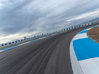 Daytime Race on Curved Road: Cloudy Skies