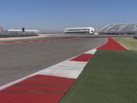 an empty track at a motorsports club with some red and white stripeing on it