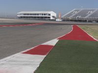 an empty track at a motorsports club with some red and white stripeing on it