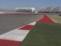 an empty track at a motorsports club with some red and white stripeing on it