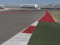 an empty track at a motorsports club with some red and white stripeing on it