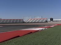 an empty track at a motorsports club with some red and white stripeing on it