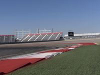 an empty track at a motorsports club with some red and white stripeing on it