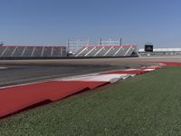 an empty track at a motorsports club with some red and white stripeing on it