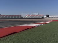 an empty track at a motorsports club with some red and white stripeing on it