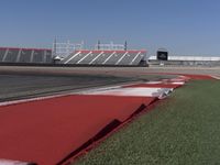 an empty track at a motorsports club with some red and white stripeing on it