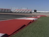 an empty track at a motorsports club with some red and white stripeing on it