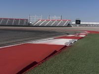 an empty track at a motorsports club with some red and white stripeing on it