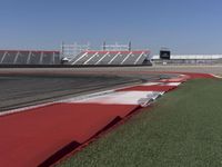 an empty track at a motorsports club with some red and white stripeing on it