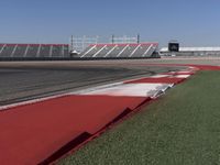 an empty track at a motorsports club with some red and white stripeing on it