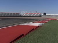 an empty track at a motorsports club with some red and white stripeing on it