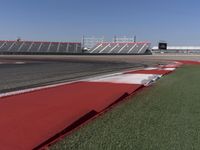 an empty track at a motorsports club with some red and white stripeing on it