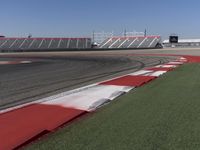 an empty track at a motorsports club with some red and white stripeing on it