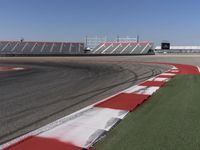 an empty track at a motorsports club with some red and white stripeing on it