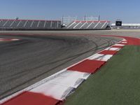 an empty track at a motorsports club with some red and white stripeing on it