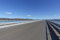 an empty road under a clear blue sky and white clouds in the distance is the highway on which there is no traffic or traffic