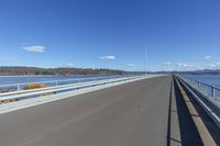 an empty road under a clear blue sky and white clouds in the distance is the highway on which there is no traffic or traffic