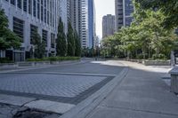 a car driving down an empty street lined with tall buildings and trees in the background