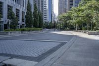 a car driving down an empty street lined with tall buildings and trees in the background