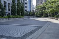 a car driving down an empty street lined with tall buildings and trees in the background