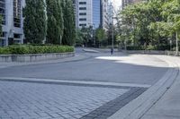 a car driving down an empty street lined with tall buildings and trees in the background