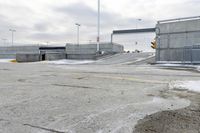 a snow covered parking lot with a bridge crossing in the back ground and no one standing or sitting