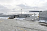 a snow covered parking lot with a bridge crossing in the back ground and no one standing or sitting