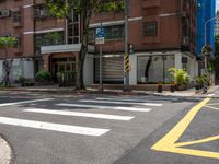 two yellow lines on the street in front of a tall building with large windows and a tree