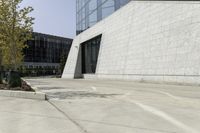 a street scene with focus on the parking lot in front of the building and trees