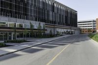 a empty road next to two tall office buildings on the other side of the street