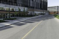 a empty road next to two tall office buildings on the other side of the street