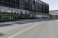 a empty road next to two tall office buildings on the other side of the street