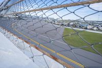 a car racing on a track by a fence with other cars at the finish line