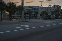 a street scene with vehicles and a light at sunset with a traffic light shining over a street