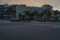 a street scene with vehicles and a light at sunset with a traffic light shining over a street