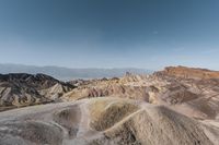 a person sitting on a rock looking out over a valley in death valley national park