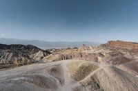 a person sitting on a rock looking out over a valley in death valley national park