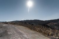 the sun shines brightly over a rocky mountain in death valley national park, california