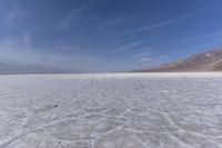 an empty expanse with no people on the sand and mountains in the distance in the distance