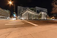 the lights of city buildings are lit up from the dark sky in an empty, deserted street