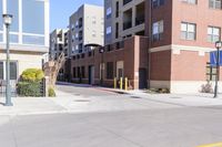 a large open street between some tall buildings and apartments in the background that is on a sunny day