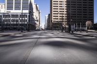 empty road lined with tall buildings during the day, in the city of denver, colorado