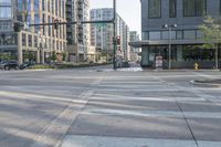 a crosswalk on a quiet street next to a tall building with parking spaces below it