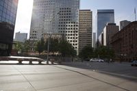 there are cars driving on the street in a city that has high buildings next to it