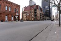 an empty street in front of buildings with tall skyscrapers behind it in the city