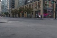 pedestrians are riding bicycles on a busy city street in a downtown setting, while the sun is setting